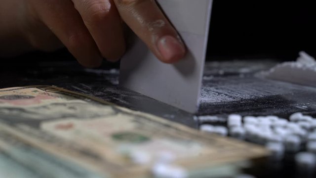 White cocaine powder on a table with dollar bills