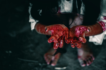 Horror Scene of a Woman with bloody hands sitting in abandoned building, Halloween murder concept.