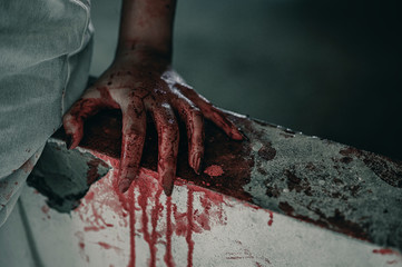 Obraz premium Horror Scene of a Woman with bloody hands sitting in abandoned building, Halloween murder concept.