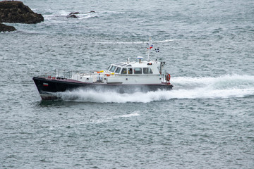 Fototapeta premium Fast tug pilot boat returning to harbour