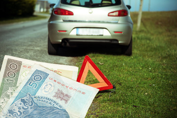 Ein liegengebliebenes Auto, Warndreieck und Banknoten Polnische Zloty