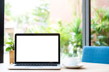 Mockup of laptop computer with empty screen with coffee cup on table of the coffee shop background,White screen