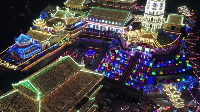 Droen shot with slowly rise up to reveal Kek Lok Si temple in night with colorful decorated lantern.