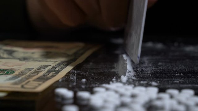 White cocaine powder on a table with dollar bills
