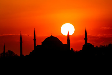 Cityscape of Istanbul with silhouettes of ancient mosques and minarets at sunset. Panoramic view,...