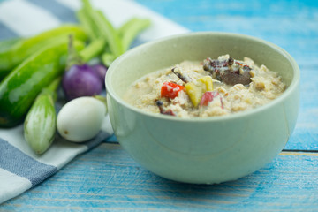 Herbed soya beans with minced pork in coconut milk served in white bowl
