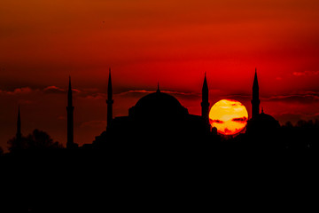 Cityscape of Istanbul with silhouettes of ancient mosques and minarets at sunset. Panoramic view,...