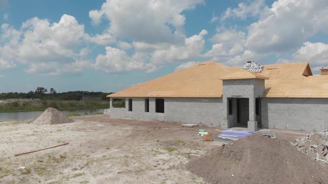 Florida new home construction on a man-made lake. Rail camera style shot.  Construction reinforced for hurricane dangers
