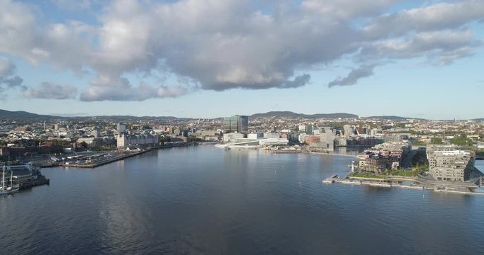 Cinema 4K drone shot with backward motion of the new Bj&oslash;rvika district, with the Lambda Munch Museum, Opera House and S&oslash;renga in a sunset in autumn fall, in Oslo Norway.