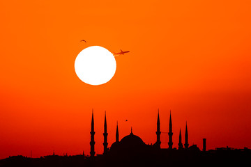 Naklejka premium Cityscape of Istanbul with silhouettes of ancient mosques and minarets at sunset. Panoramic view, The Maiden's Tower, Galata Tower, Hagia Sophia, The Blue Mosque and Topkapı Palace in Istanbul.