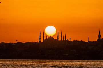 Cityscape of Istanbul with silhouettes of ancient mosques and minarets at sunset. Panoramic view, The Maiden's Tower, Galata Tower, Hagia Sophia, The Blue Mosque and Topkapı Palace in Istanbul.