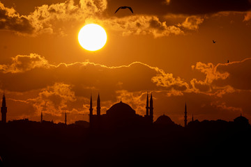 Naklejka premium Cityscape of Istanbul with silhouettes of ancient mosques and minarets at sunset. Panoramic view, The Maiden's Tower, Galata Tower, Hagia Sophia, The Blue Mosque and Topkapı Palace in Istanbul.