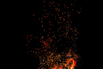 Fototapeta na wymiar Sparks from a fire on a black background isolate. Concept fire grill heat weekend barbecue.