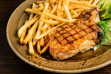 steak with french fries on the wooden background