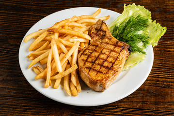 steak with french fries on the wooden background