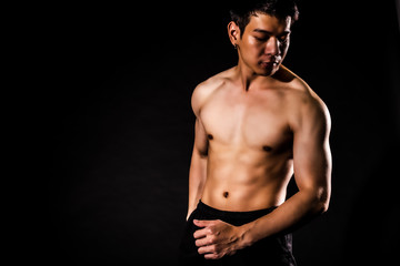 Fototapeta na wymiar sport man standing showing muscle bodybuilding on black backgrounds, fitness concept, sport concept