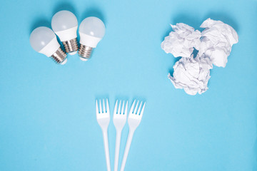 separation of waste led light paper and plastic forks on blue background