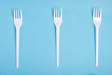 separation of waste plastic forks on blue background flat lay