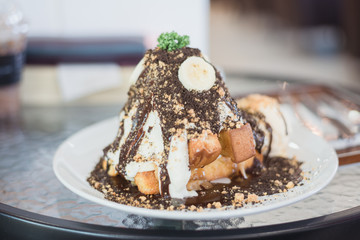 Ice cream cake or honey banoffee toast menu in white dish on table at restaurant.Eating party concept.