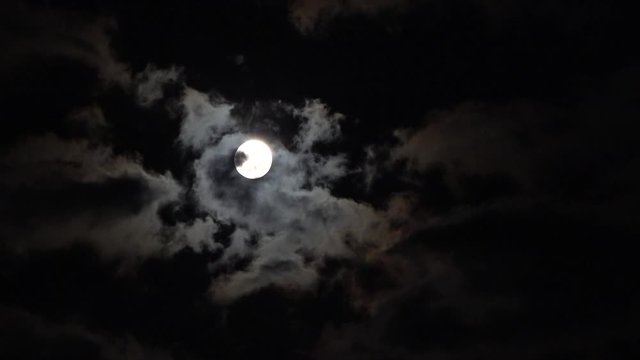 Dark night black sky clouds moving quickly across full moon