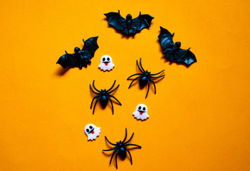 Halloween holiday concept, Bats, black spiders and tiny ghost in orange background with copy space for text, Top flat view wallpaper