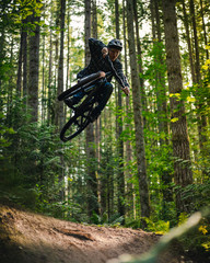 Stylish Mountain Bike Jump Trick Catching Air in Forest