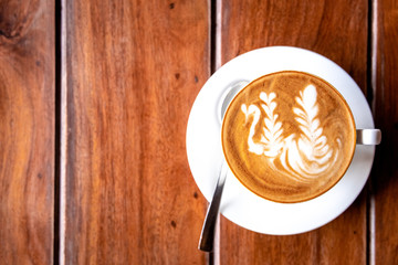Delicious cappuccino placed on a wooden surface. Top down view