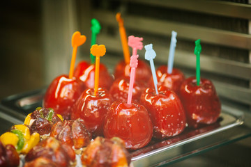 Apple candy. Halloween celebration concept. Vintage processed. Red sugar apples on a stick. Eastern sweets, food