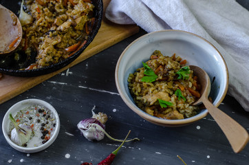 A pan and plate of homemade pilaf with garlic and  chilli pepper