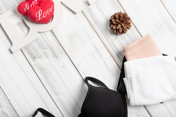 Woman underwear set on white wooden background with love heart symbol and text,top view