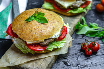 Healthy homemade burger with beef, tomatoes, cheese and basil