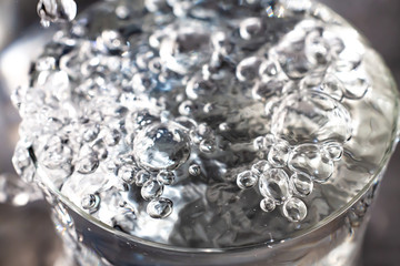 Clear water bubbles floating in transparent glass, Close up & Macro shot, Selective focus, Healthy Drink concept