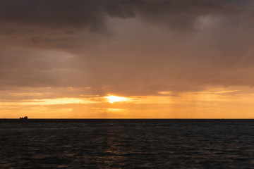 Beautiful beach sunset with big rain clouds and golden light sky  background