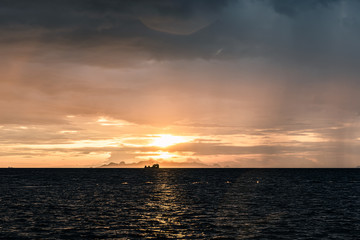 Beautiful beach sunset with big rain clouds and golden light sky  background