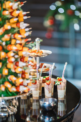 portions of mousse creamy desserts with chocolate. various snacks in three-storey services. Sweets, saltwater, cheese  balls, pickles, cheese tree, chocolate mousse, served on trays