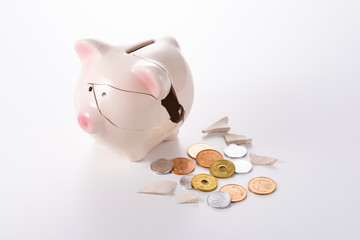 割れた貯金箱と硬貨