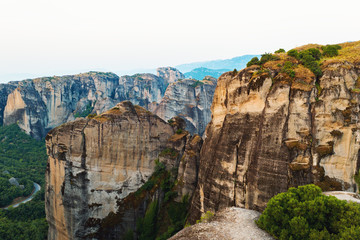 Aerial view of a slide from a drone on a panorama of a mountain range. Kalampaka city, Greece. View of the cliffs of Meteora and the monasteries of Meteora. Many ancient Orthodox monasteries