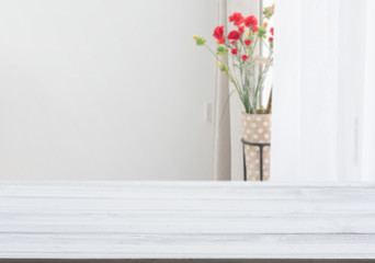 White wood table top with flower pot in living room background