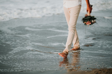 Hands of wedding groom in a white shirt dress cufflinks. Boutonnière. groom buttoning the front of his jacket.   