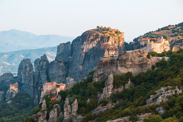 Aerial view of a slide turn from a drone on a panorama of a mountain range and roofs of residential buildings. Kalambaka city, Greece. The tops of the rocks of Meteora. Orthodox monasteries Meteora.
