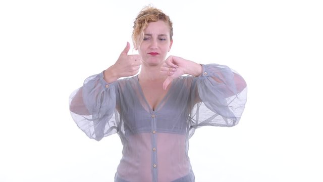 Confused beautiful blonde woman choosing between thumbs up and thumbs down