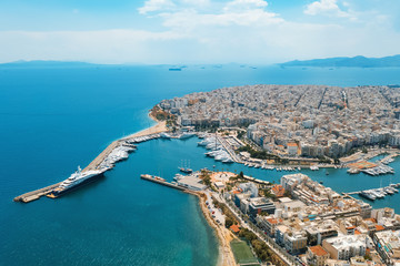 Piraeus, Greece aerial view drone on panorama of buildings of residential and administrative buildings of the city in summer on sunny day. Roof plan aerial view of the blue sea. Front view