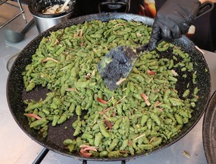 Chef cooking Spatzle with cream and speck, a typical dish of German speaking populations It's a soft egg noodle with spinach