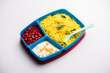 Lunch Box / Tiffin for Indian kids, contains lemon rice, nahi-boondi and pomegranate or Anar. selective focus