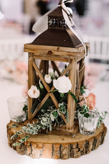 Wedding decor made of natural materials in rustic style. Wooden lantern filled with moss stands