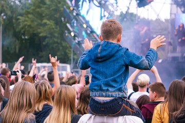 Children sit around the neck at a street concert