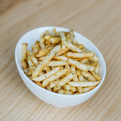 Hamburger and french fries. Tasty french fries on cutting board, on wooden table background. Hamburger and fried potatoes on a wooden table
