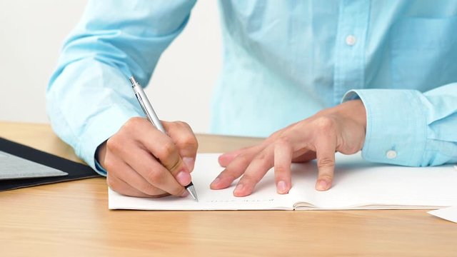 ノートに書く男性