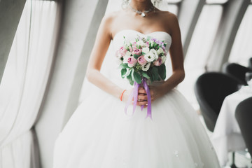 Portrait of stunning bride with long hair posing with great bouquet