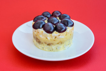 The legendary Tiffany layered salad with grapes, chicken and cheese on the red background.